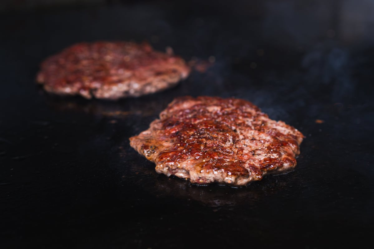 Sizzling burger patties on the grill