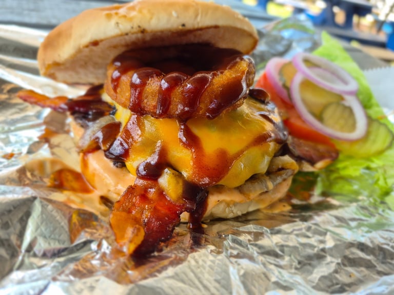 Gourmet cheeseburger with grilled sausage patty, melted cheese, and caramelized onions on a toasted bun with fresh toppings